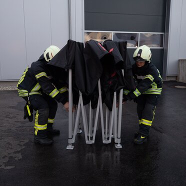 Vigili del fuoco di Ulm in Germania aprono un gazebo pieghevole 3x3m nero Ecotent personalizzato con scritta rossa
