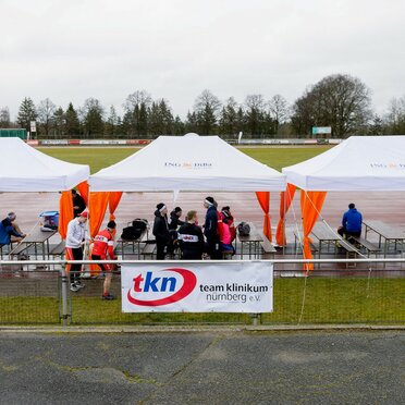 Serie di gazebo per eventi 6x3m bianchi con tende angolari arancioni personlizzati con logo IngDiba per evento all'aperto su un grande campo sportivo