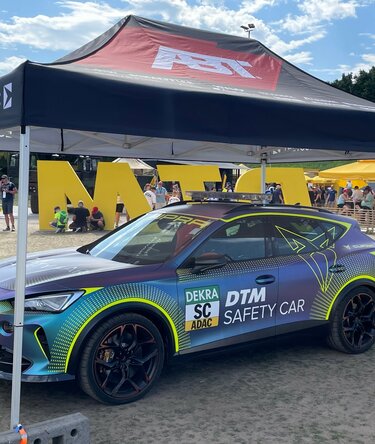Gazebo pieghevole ABT 4,5x3  completamente personalizzato copre un'atomobile cupra durante un'evento motorsport