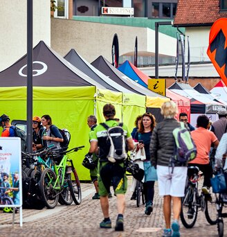 fila di gazebo 4x4 m nero e lime con pareti laterali logo Ergon al Brixen Bike Festival