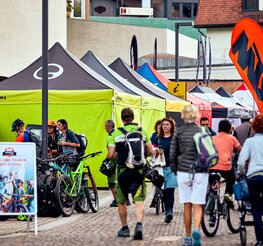 Zeltreihe von 4x4 Faltzelten in Schwarz und Limone mit Ergon-Logo an den Seitenwänden beim Brixen Bike Festival