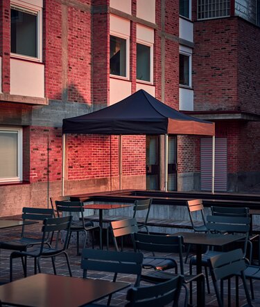 Der schwarze 3x3 m Faltpavillon dient als Outdoor-Überdachung auf der Terrasse.