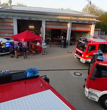 Gazebo 3x4,5 rosso per vigili del fuoco con scritta bianca personalizzata circondato da automezzi di emergenza dei pompieri