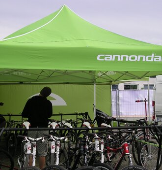 Il gazebo promozionale "Cannondale" è di 4,5x3 m e di colore verde. Le biciclette sono posizionate sotto il gazebo pieghevole.