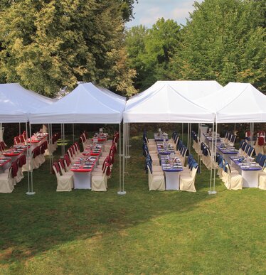 Sistema di gazebo bianchi 8x4 per un catering di un matrimonio su un prato organizzato sa Ringhotel Woerlitz