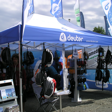 Gazebo blu 4,5x3 Deuter personalizzato con teli laterali e bandiere a goccia pubblicitarie con logo per vendita zaini sportivi durante manifestazione. Ecotent