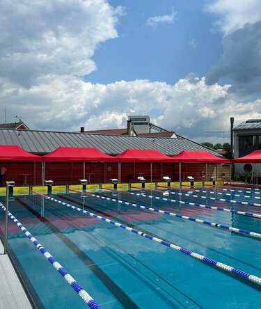 Cinque gazebo rossi 8x4 al bordo di una piscina olimpionica esterna