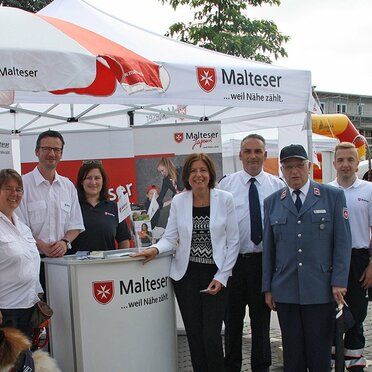 Gazebo bianco 3x3m personalizzato con logo Malteser e telo laterale utilizzato per esposizione