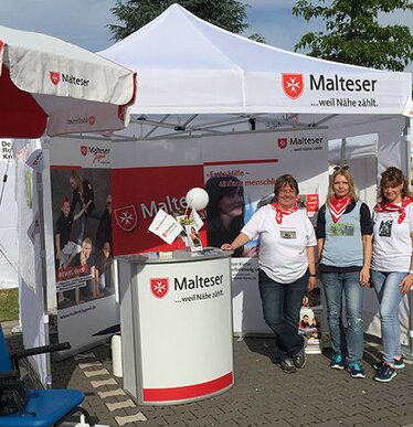 Gazebo bianco 3x3m personalizzato con logo Malteser e telo laterale utilizzato per esposizione