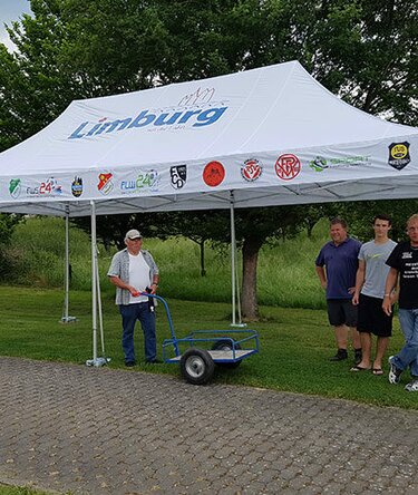 Gazebo 8x4 m bianco con loghi associazioni Limburg in un giardino ripara delle persone