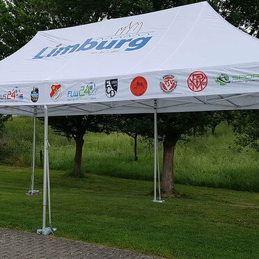 Gazebo 8x4 m bianco con loghi associazioni Limburg in un giardino