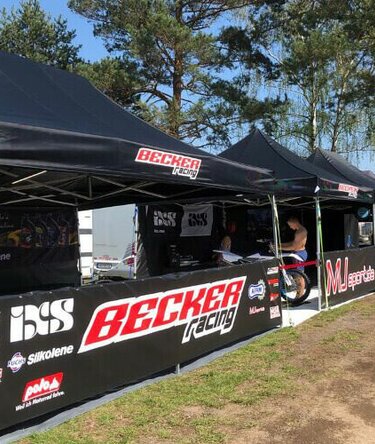 Gazebo piegheole nero 6x4 m con teli laterali personalizzato con stampa logo Becker Racing utilizzato come paddock moto