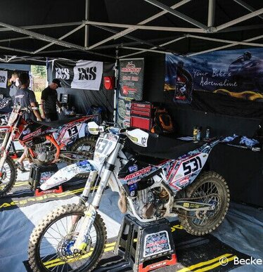 Gazebo piegheole nero 6x4 m con teli laterali personalizzato con stampa logo Becker Racing utilizzato protegge tante motocross