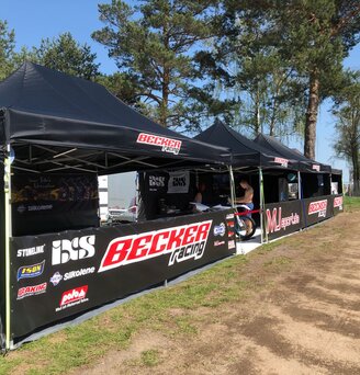 Gazebo piegheole nero 6x4 m con teli laterali personalizzato con stampa logo Becker Racing utilizzato come paddock moto